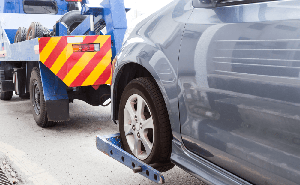 A tow truck at night on a highway, ready for a rescue operation.